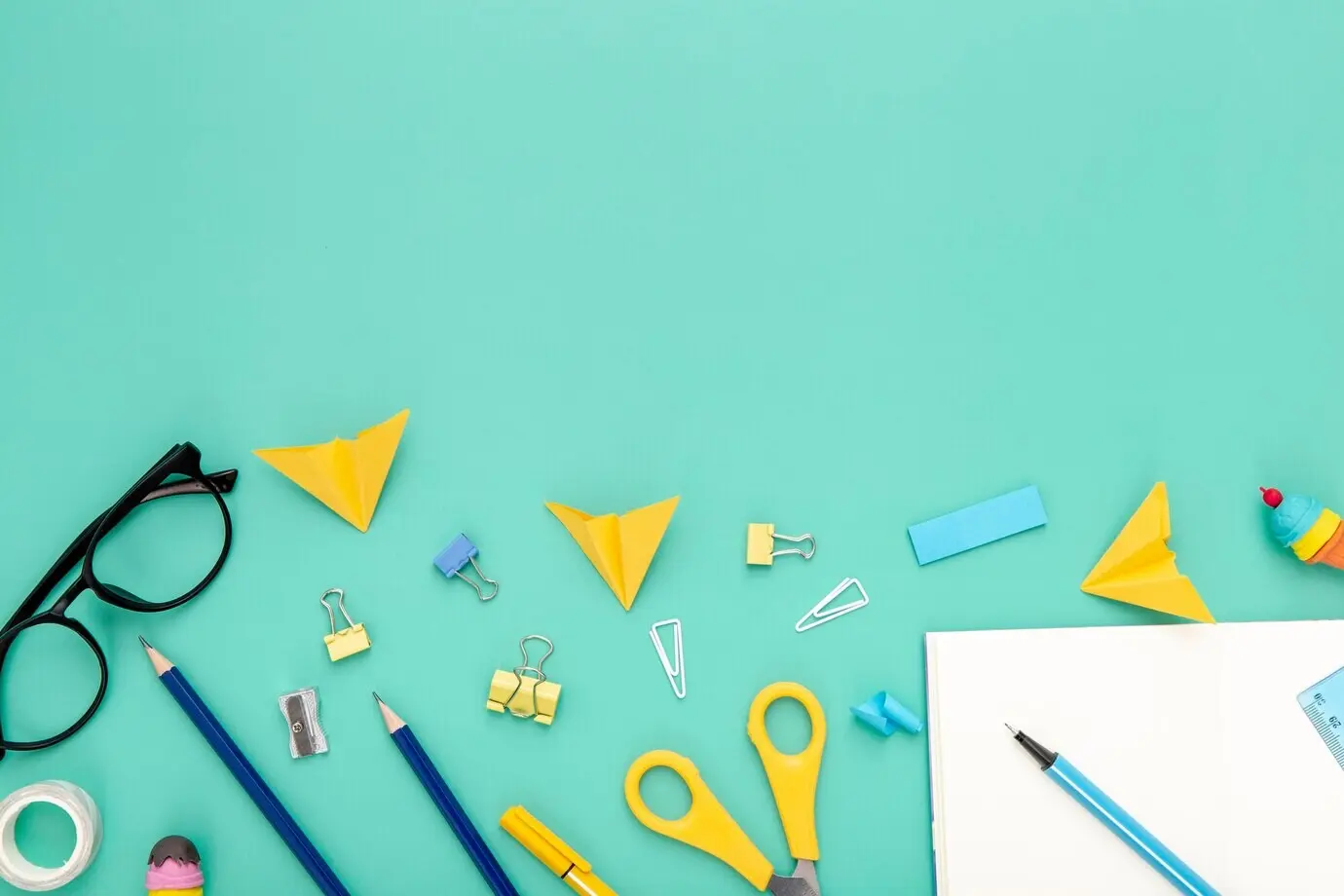 Flat-Lay-Komposition aus Schreibtischgegenständen auf grünem Hintergrund